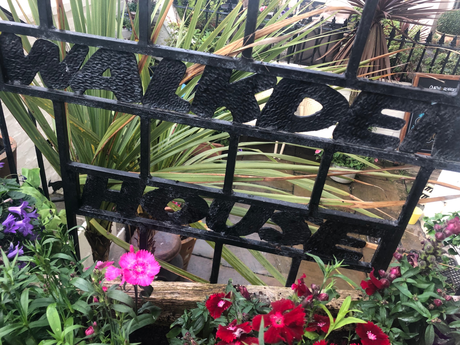 Wrought-iron Walkden House gate framed by garden planters